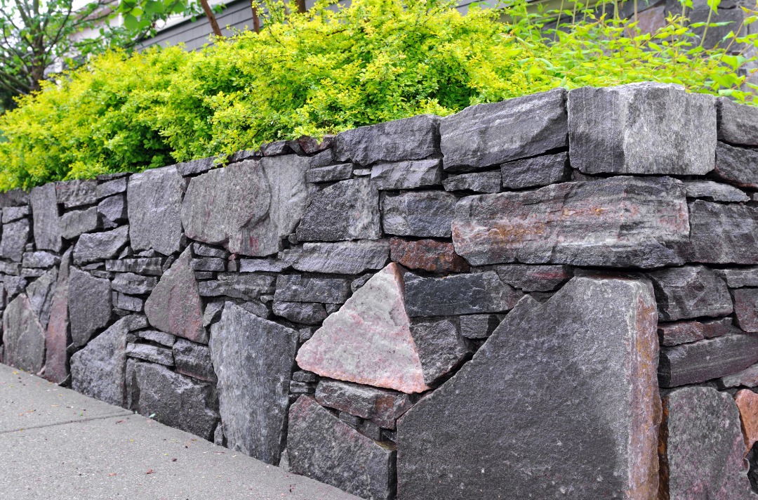 A gorgeous retaining wall with lush green plants.