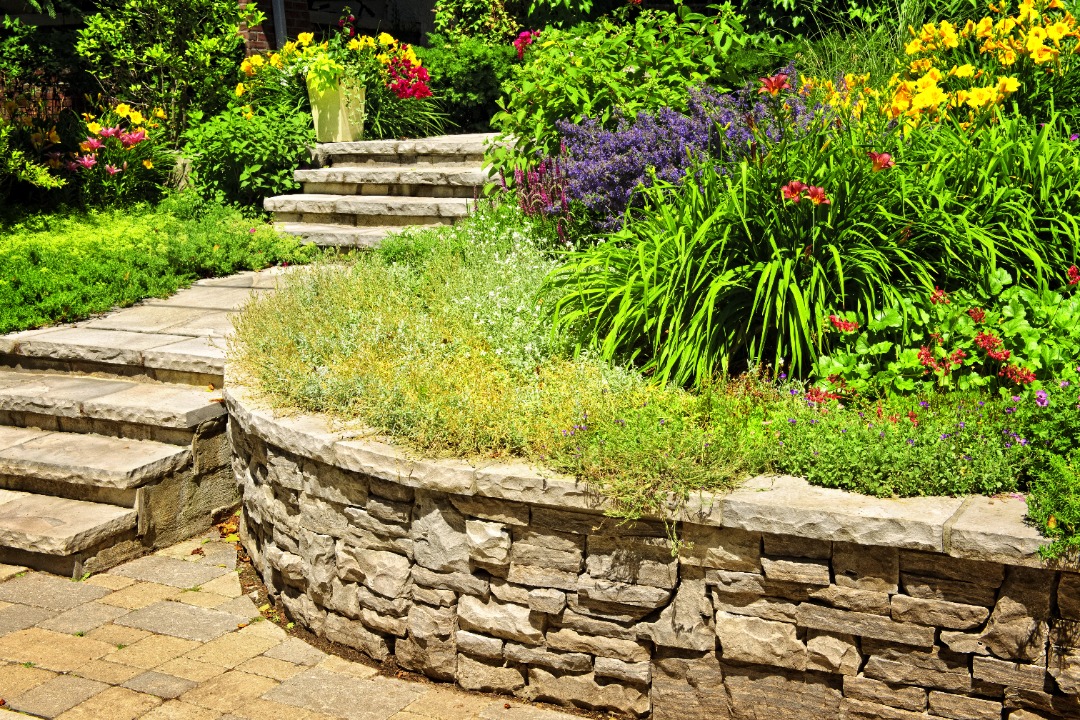 A sturdy retaining wall with a plethora of vibrant plants and flowers.