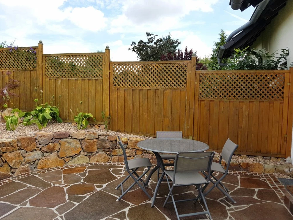 Patio hardscaping with stone flooring and retaining wall creating a functional outdoor seating area for Tennessee homes.
